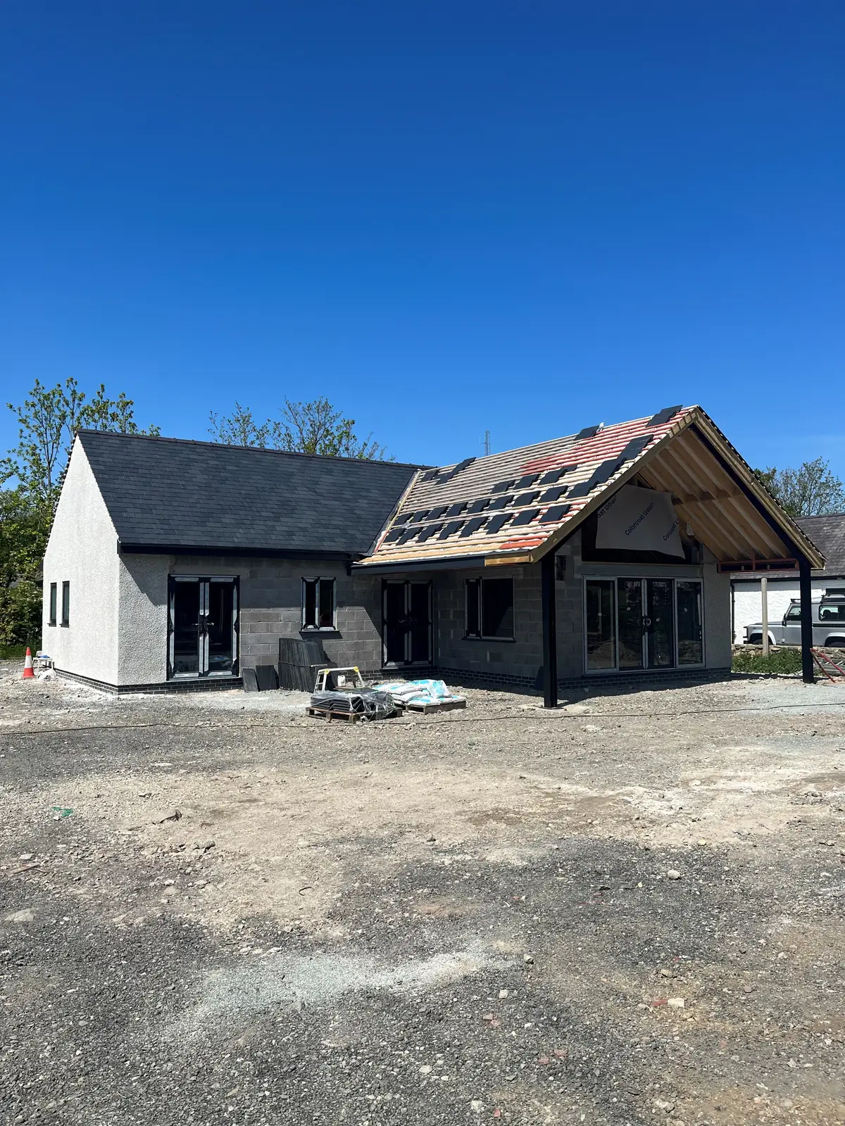 Single-storey new build with one wing slated and the other battened, ready for slate. One of our jobs.