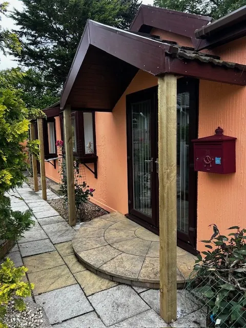 Porch canopy over a front door with a curved slab path. One of our jobs.