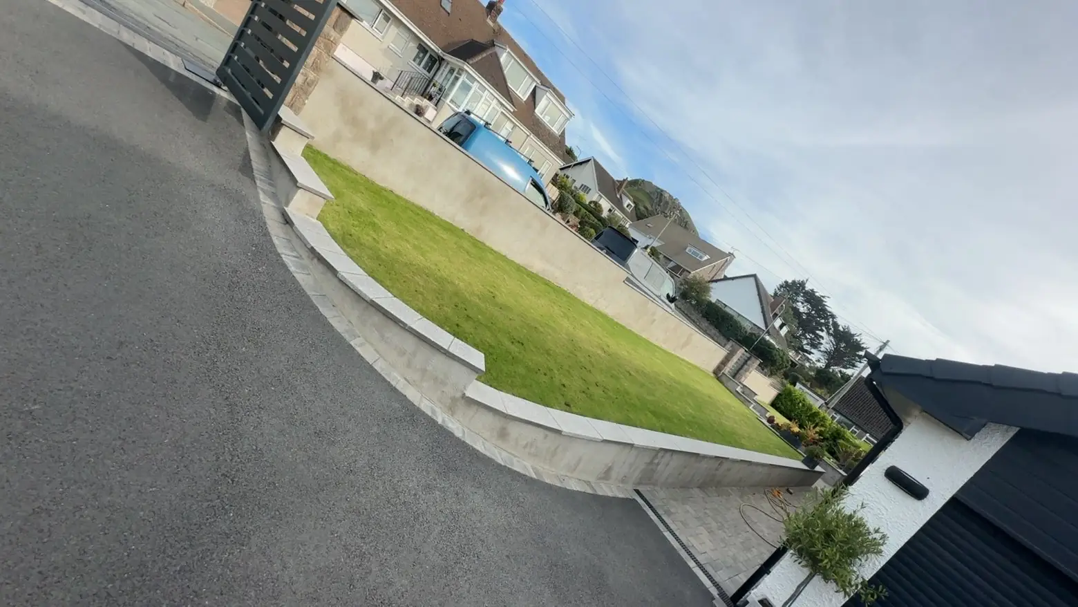 Tarmac drive curving past a kerbed lawn. One of our jobs.
